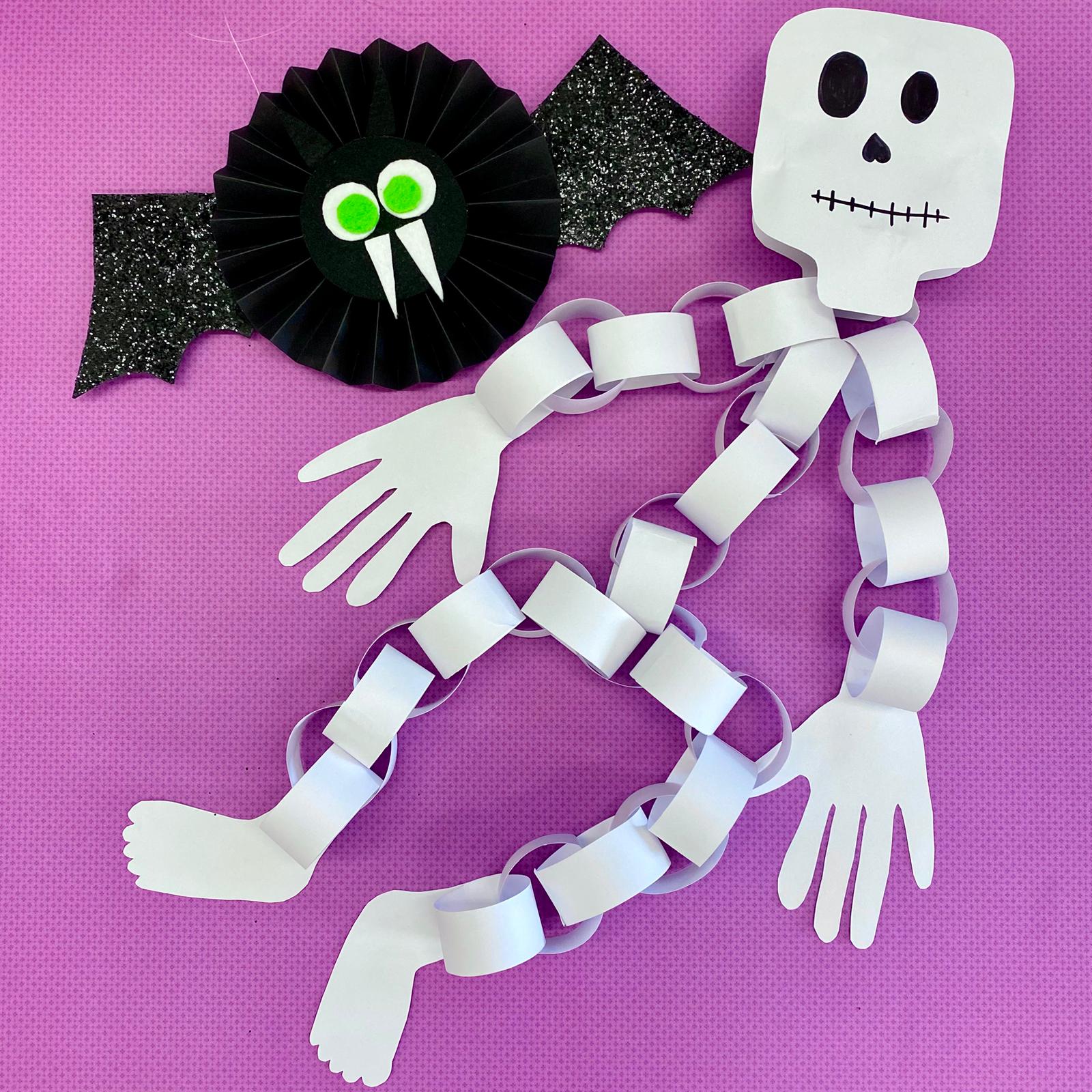 Eine gebastelte Fledermaus und ein Skelett aus Papierstreifen als Dekoration für Halloween
